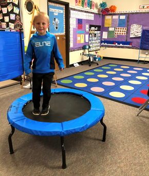 Kindergartener jumping on fitness trampoline to increase classroom activity