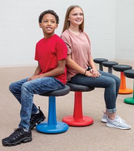 two students sitting on active stools